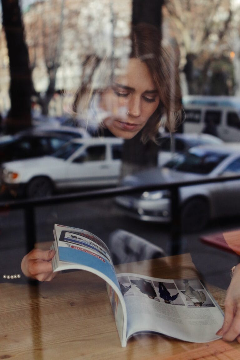 Woman reading magazine in cafe