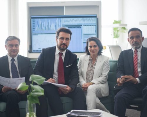 Professional team in corporate attire ready for a meeting, engaged in discussion.
